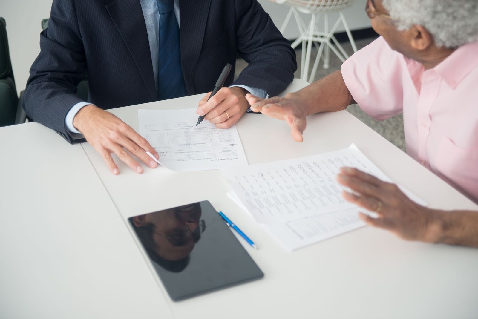 Two people going over Medicaid behavioral health benefit documents together at an office table